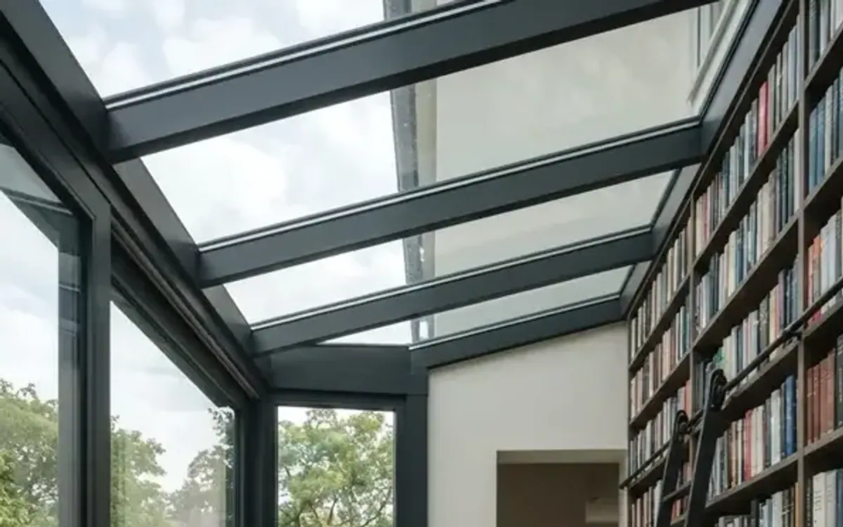 Bücherregal mit Leiter an der Hauswand in einem Wintergarten