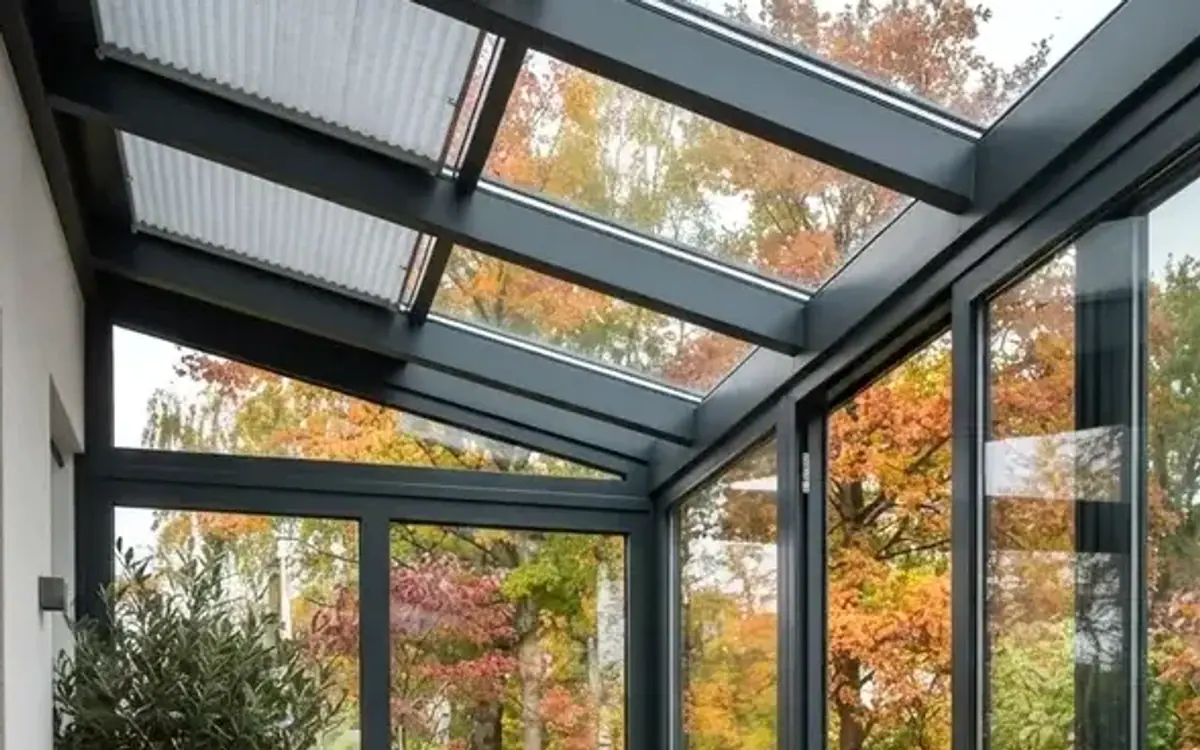 Wintergarten mit Sesseln und Herbstlaub im Garten