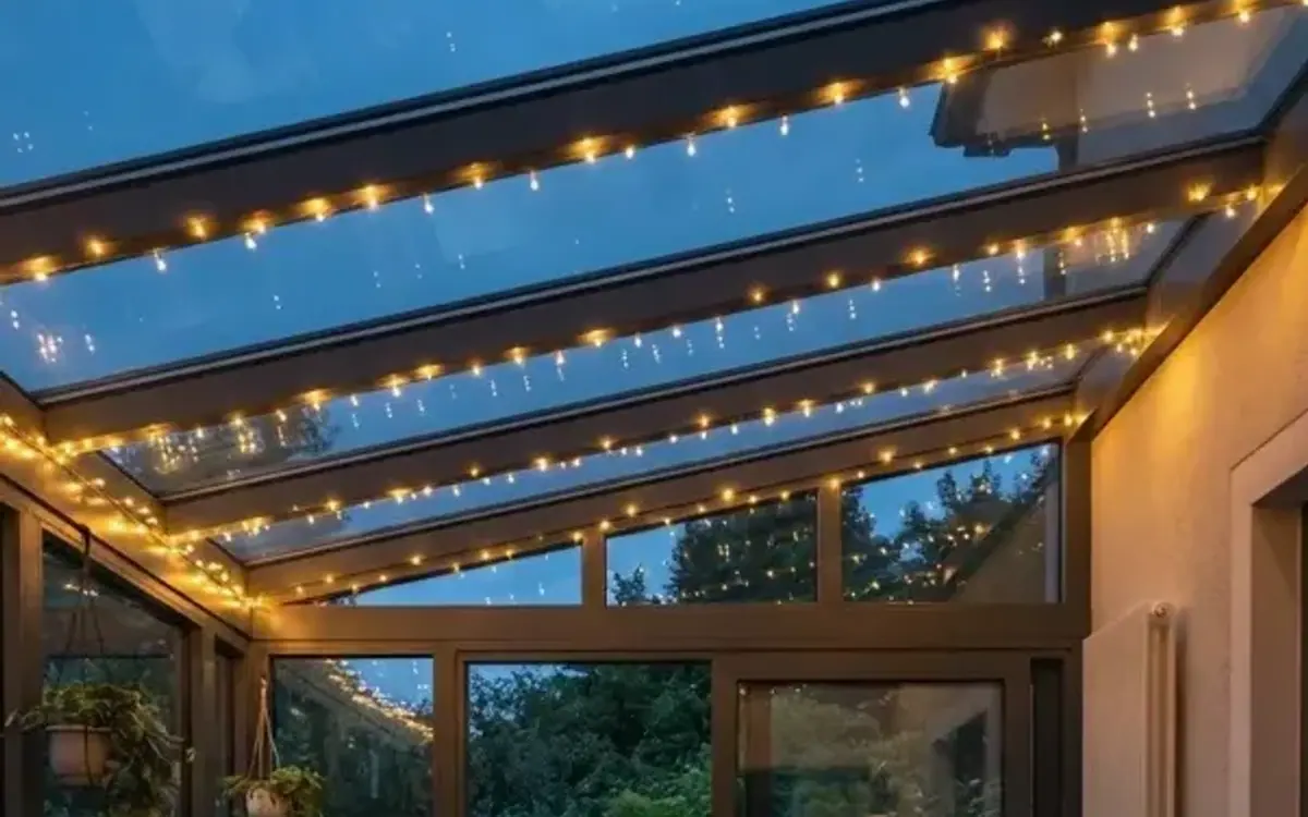 Lichterketten an den Profilen eines Glasdachs in der Abenddämmerung