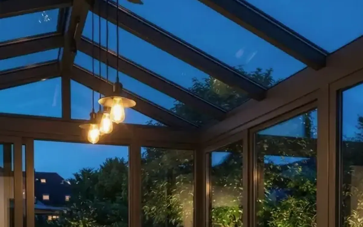 Pendelleuchten mit Glühbirnen unter einem Glasdach am Abend