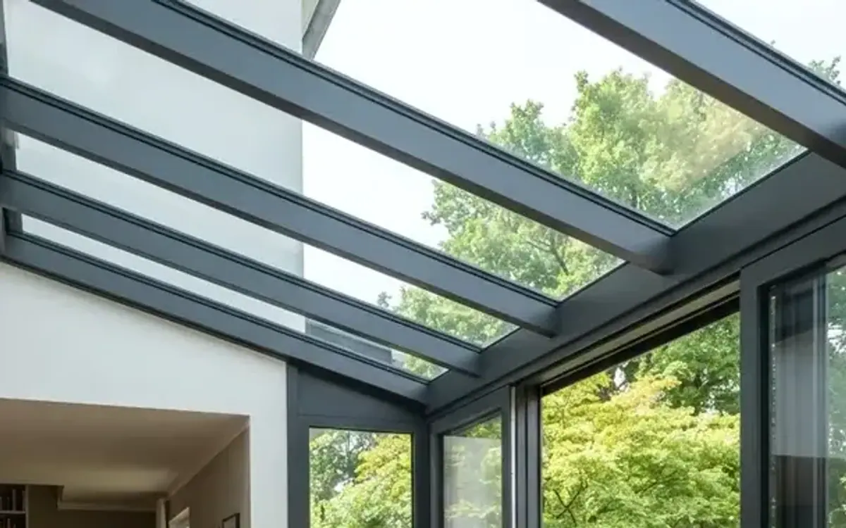 Wintergarten mit Glasdach als Erweiterung eines hellen Wohnraums